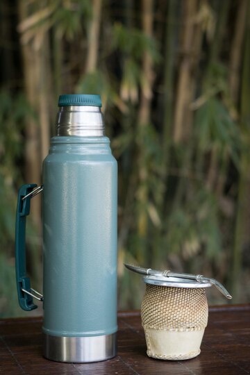 vertical closeup cup yerba mate infusion with thermos